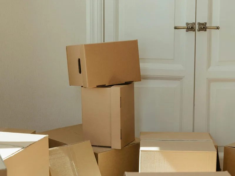 Stacked cardboard moving boxes beside a doorway