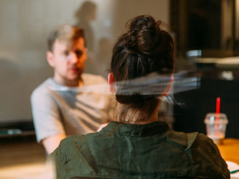 Two people talking across a table.