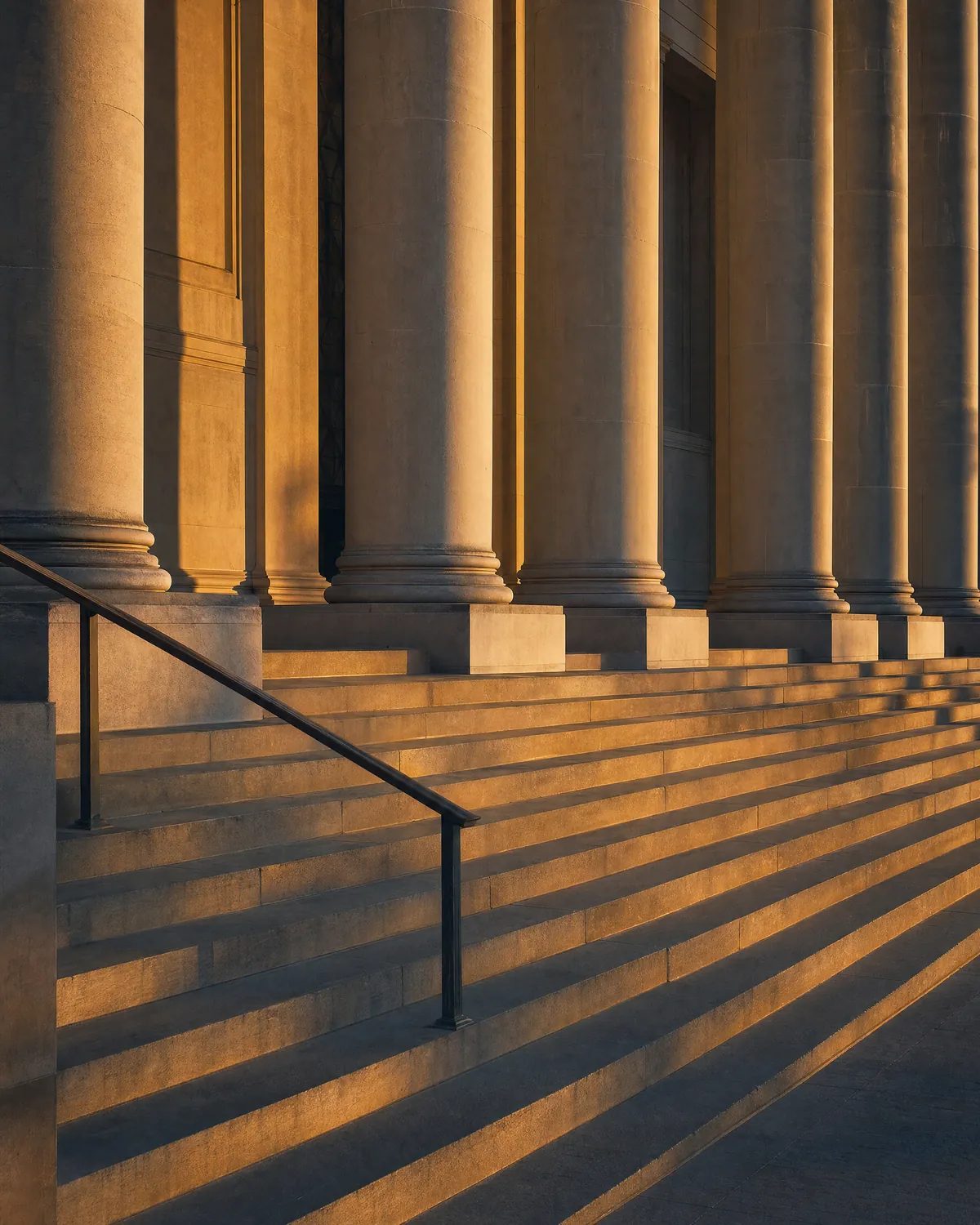Illustration: Stone steps and columns of a civic building in evening light.