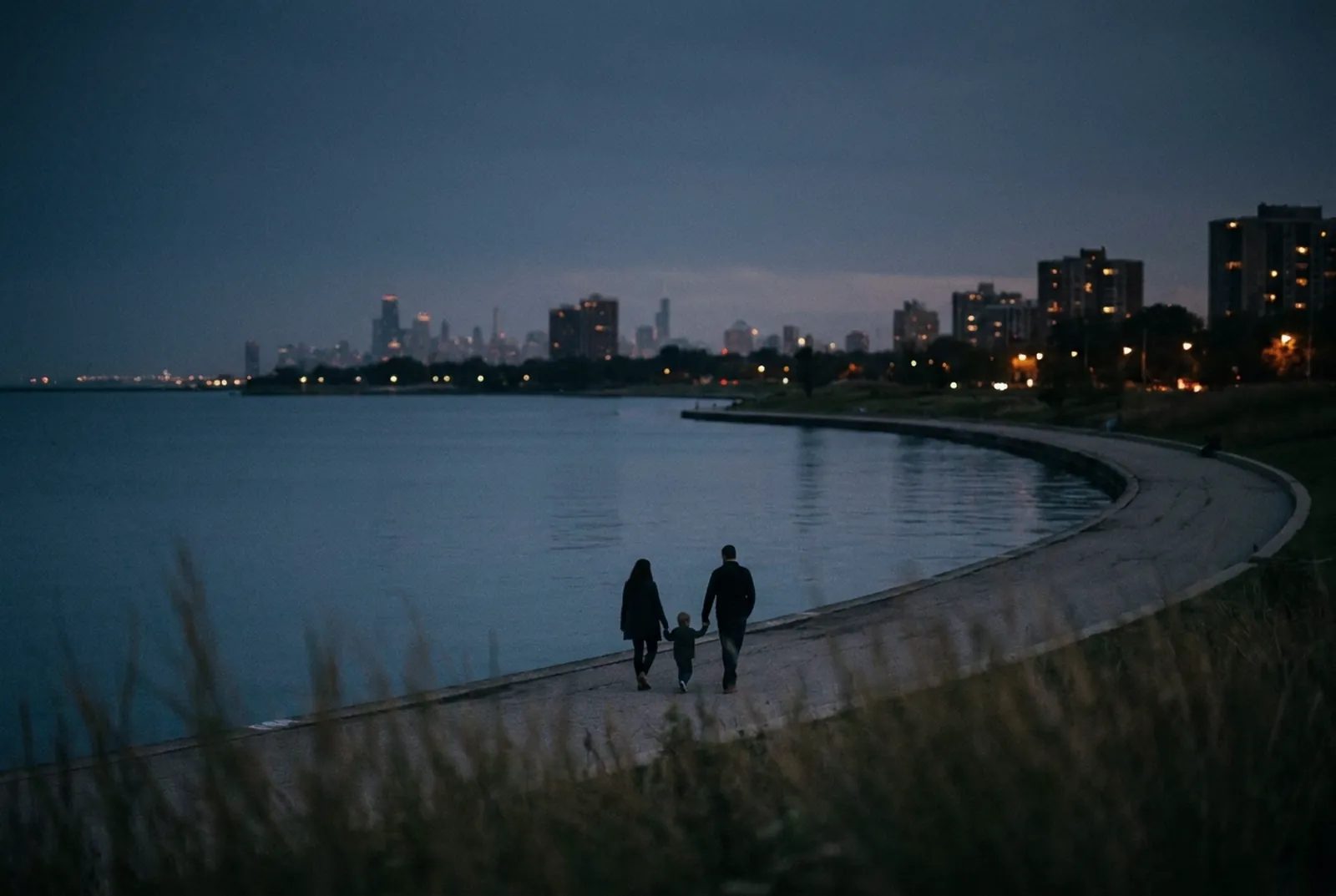 Illustration: an adult and a small child seen from behind, walking along the Lake Michigan shoreline path at dusk