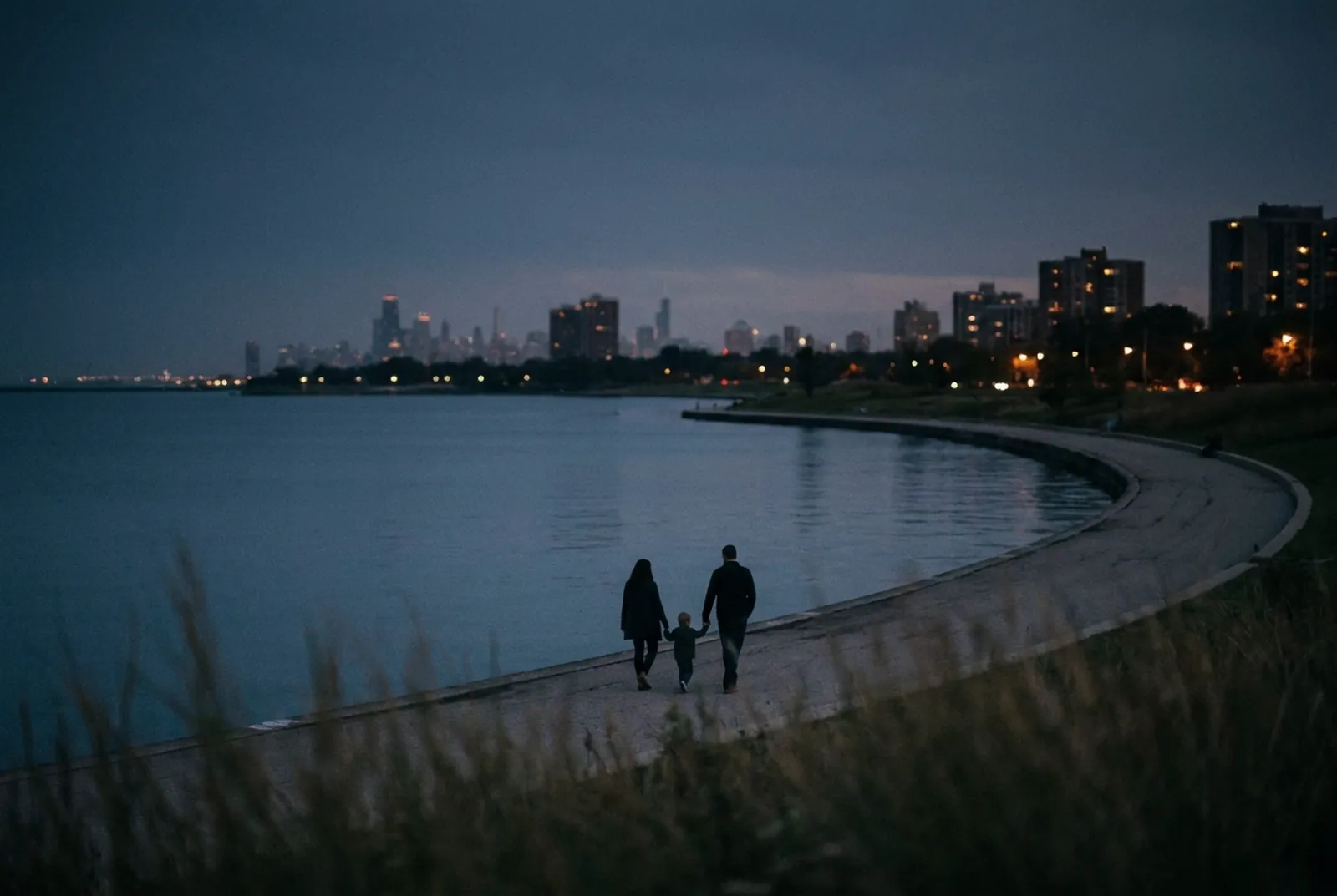 Illustration: an adult and a small child seen from behind, walking along the Lake Michigan shoreline path at dusk