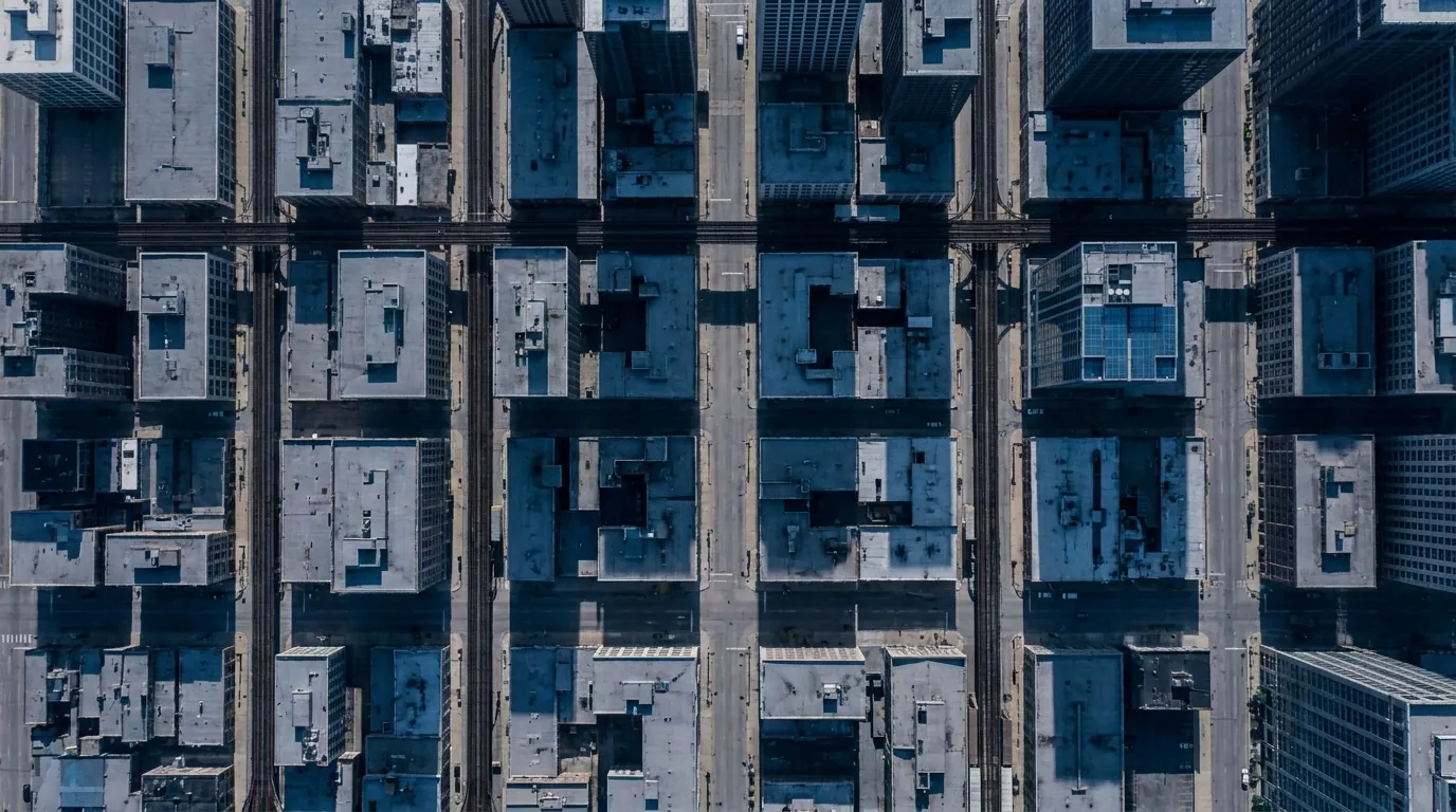 Illustration: aerial view straight down on the Chicago Loop, with rooftops, streets and elevated train tracks forming a tight grid