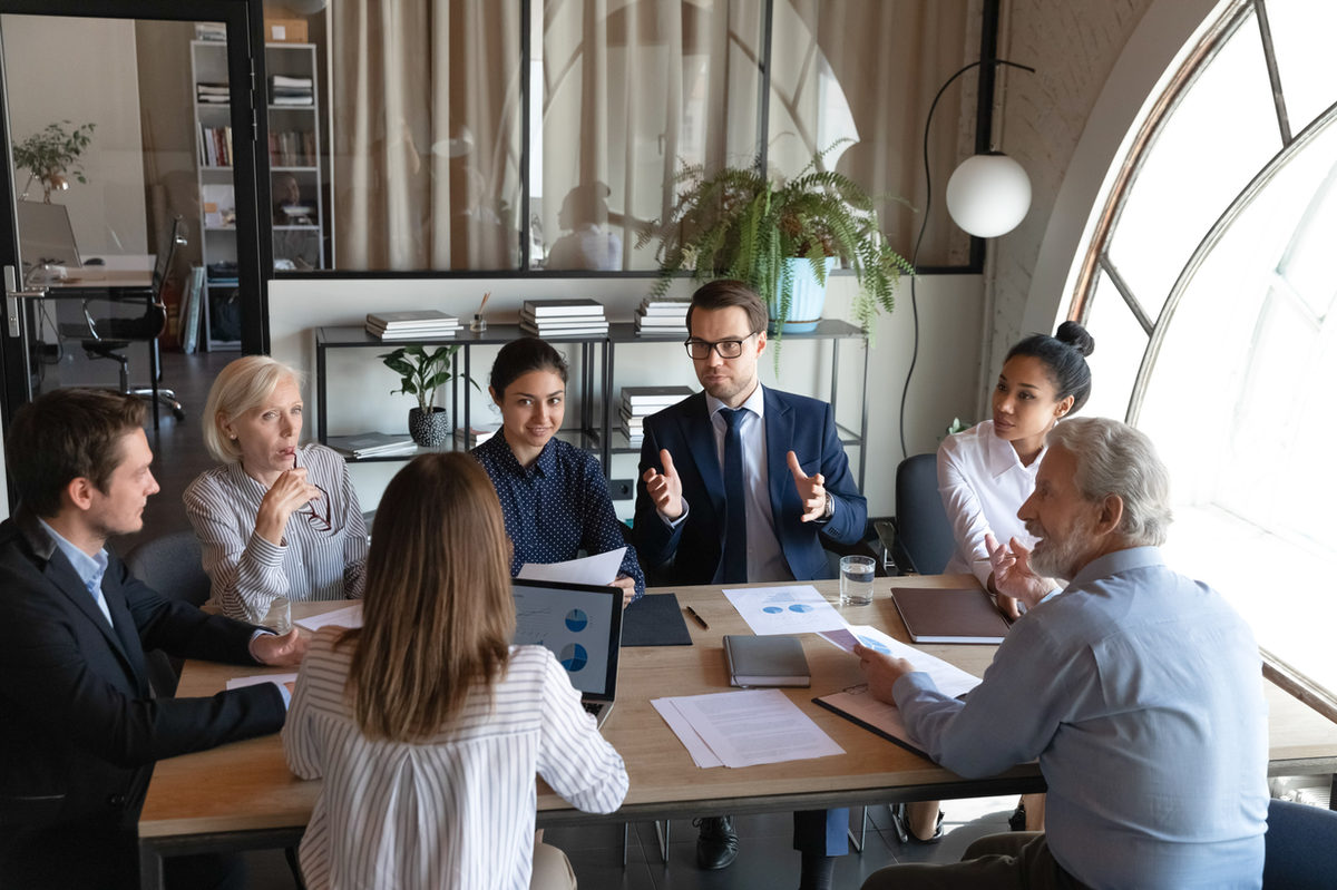 A group discussing papers around a meeting table.