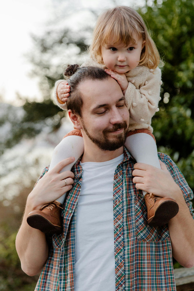father carrying daughter smiling