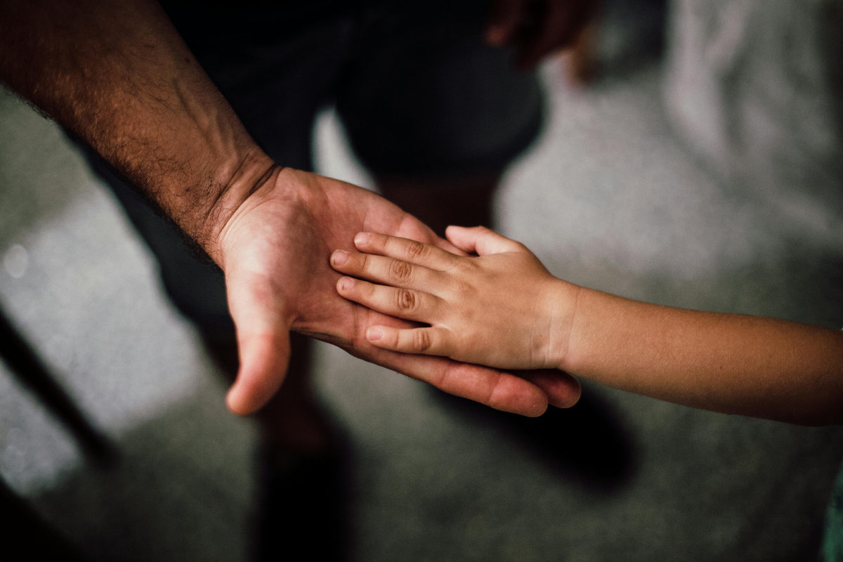 father holding sons hand