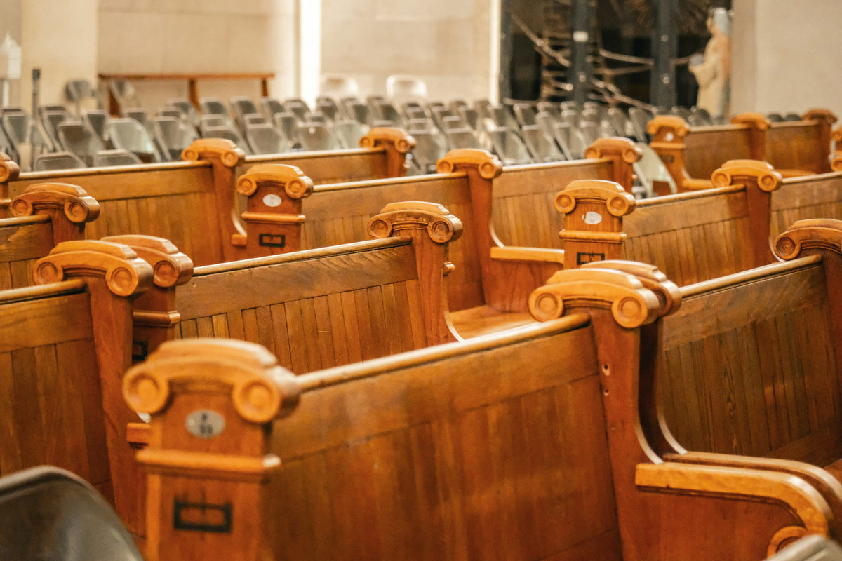 Rows of wooden benches in a large interior.