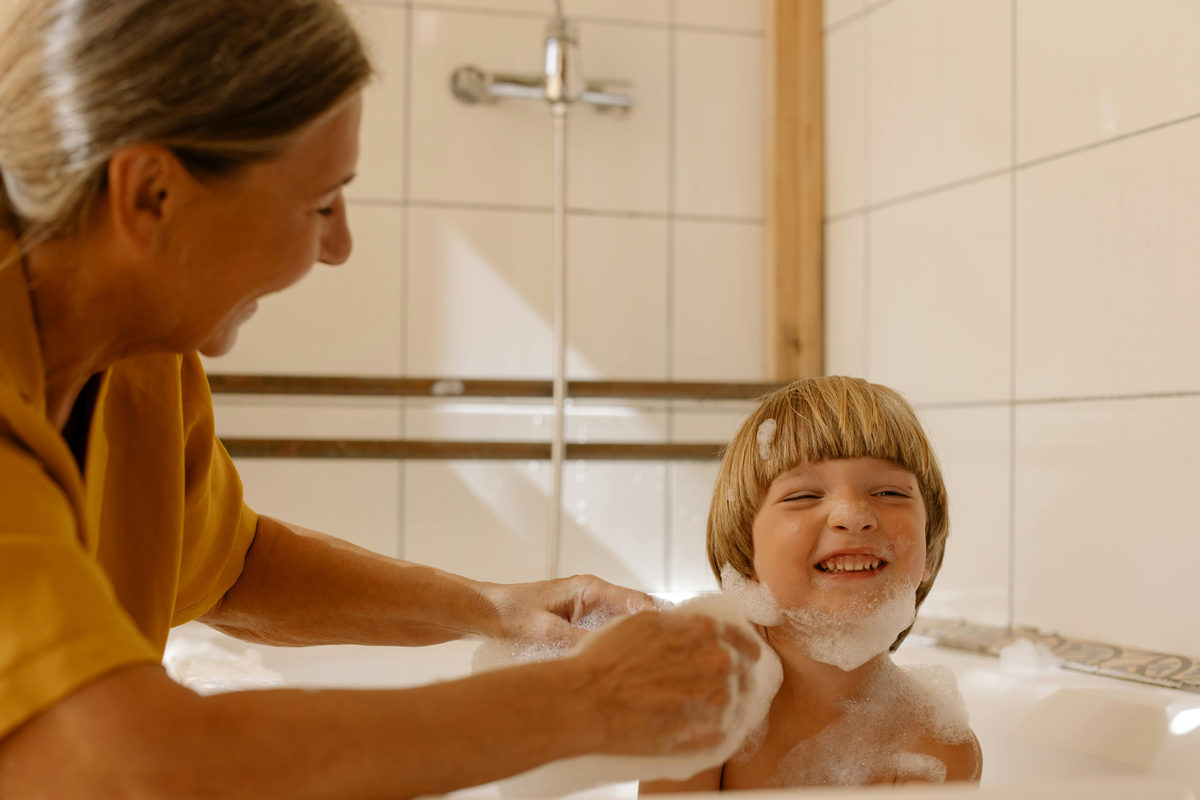 An older adult helping a child in a bathroom.