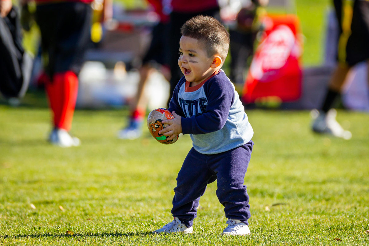 niño pequeño jugando al fútbol americano