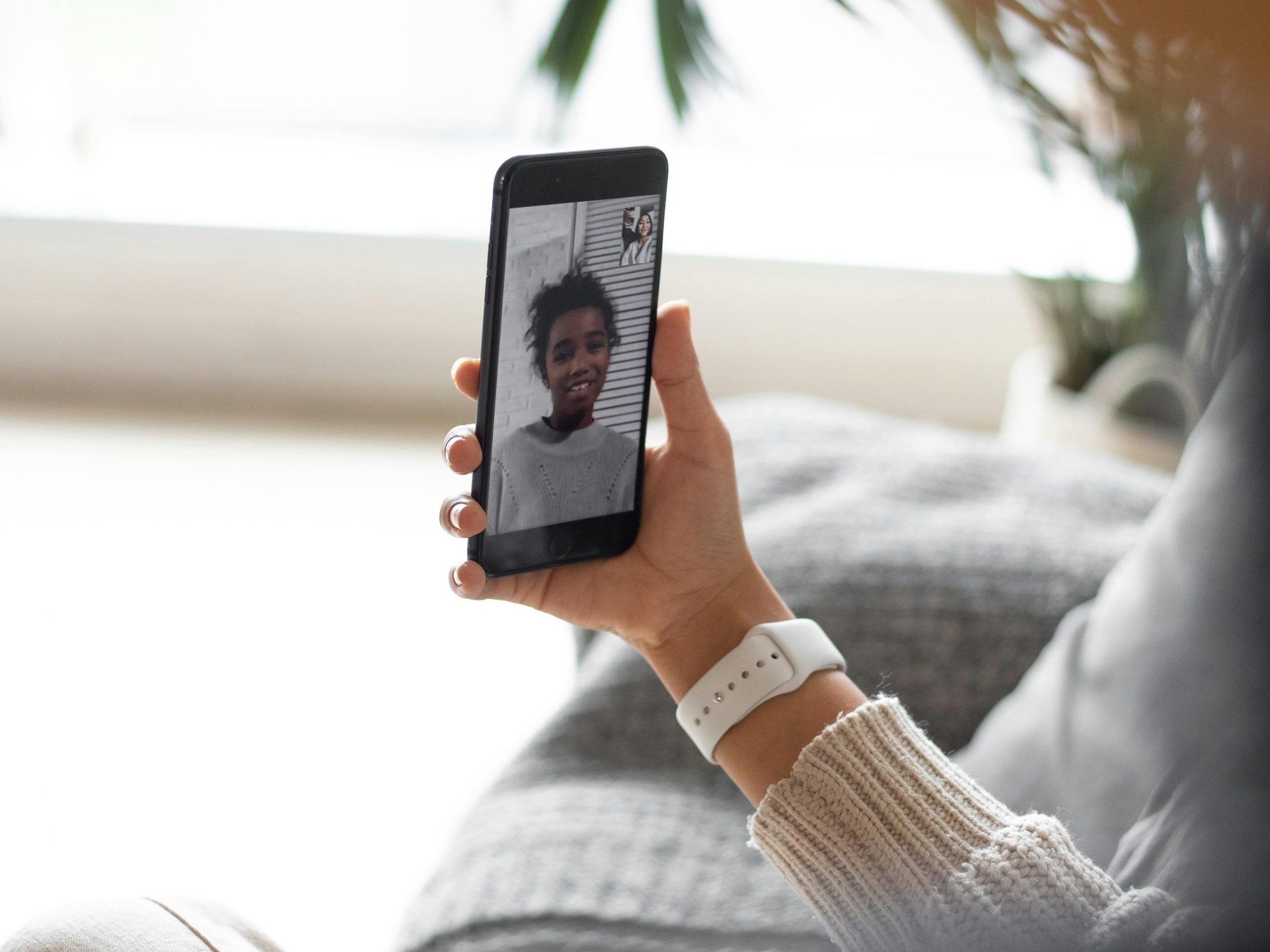 A hand holding a phone during a video call.