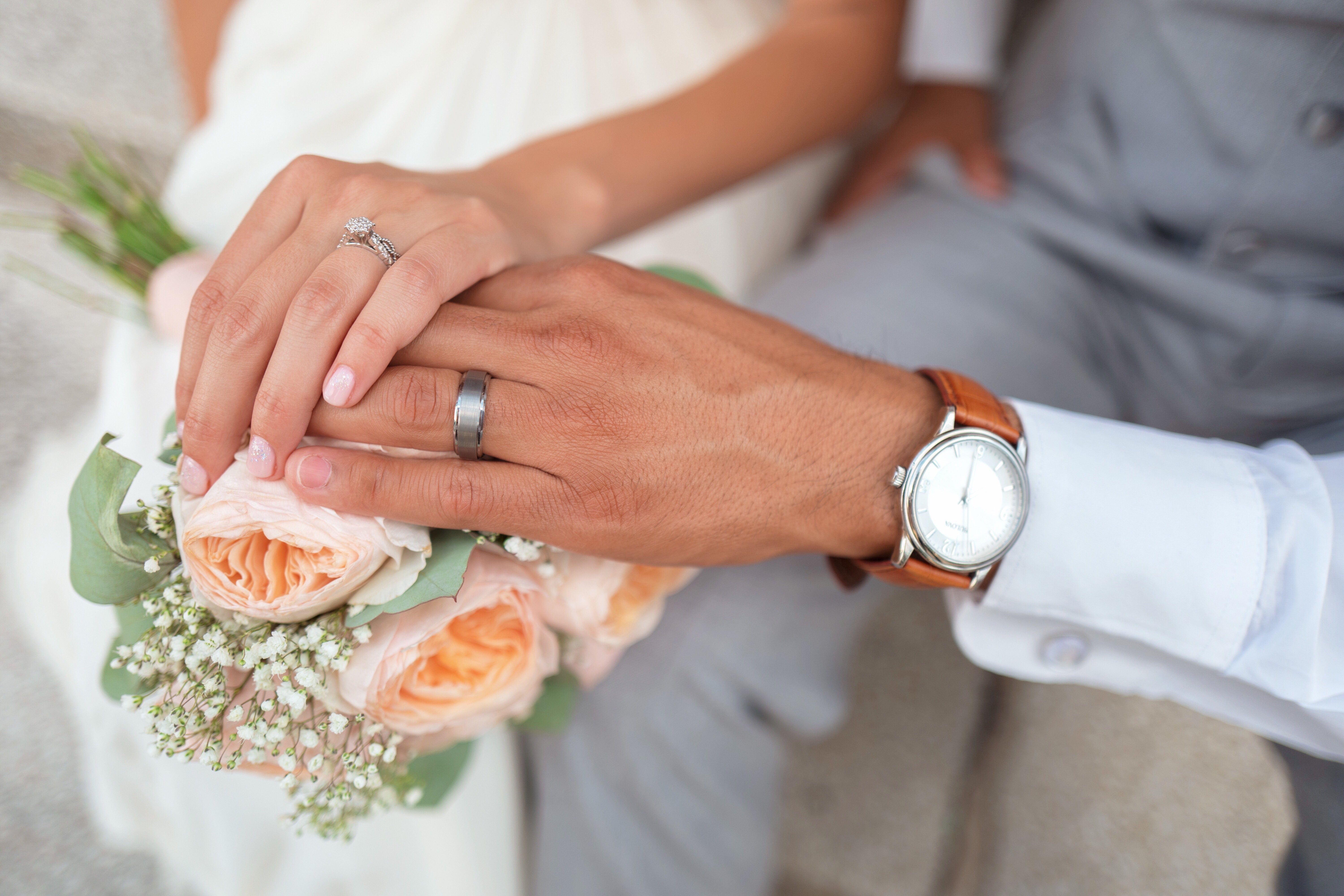 pareja casada tomándose de las manos sobre un ramo