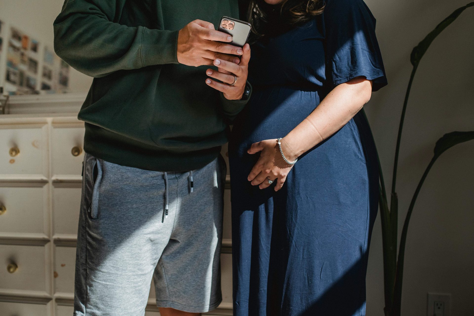 Two adults looking at a phone together indoors.