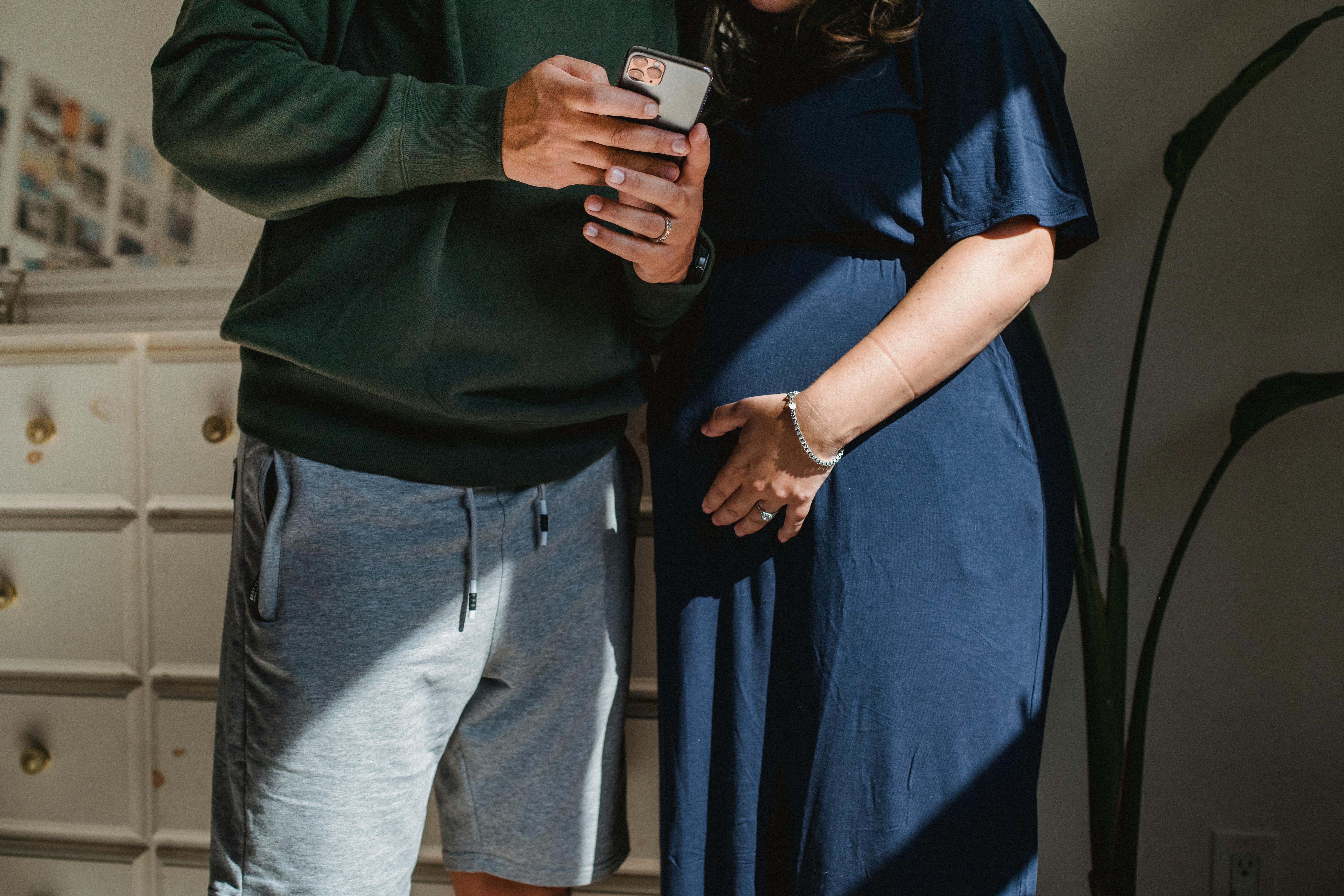 Two adults looking at a phone together indoors.
