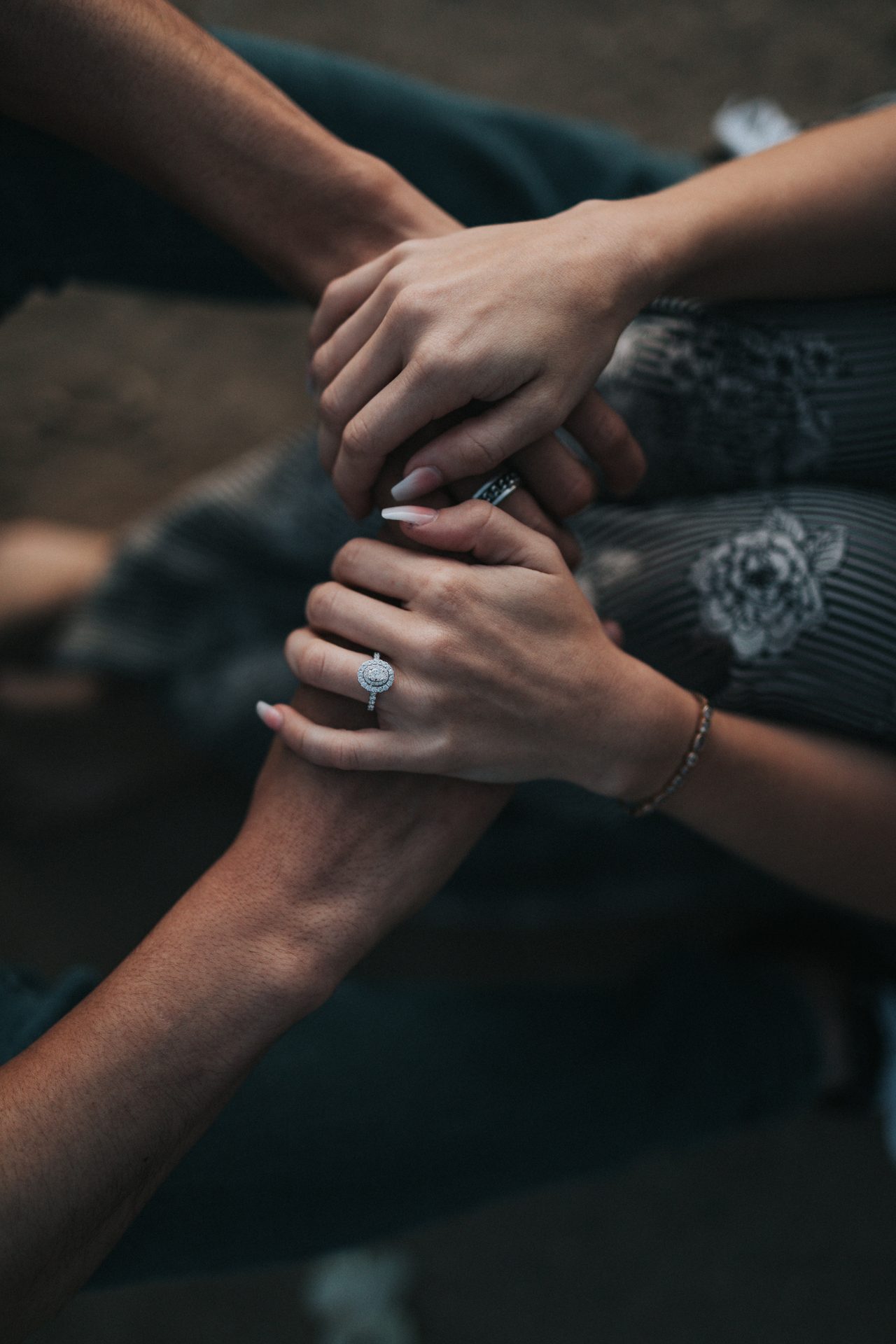 Two people holding hands, with rings visible.