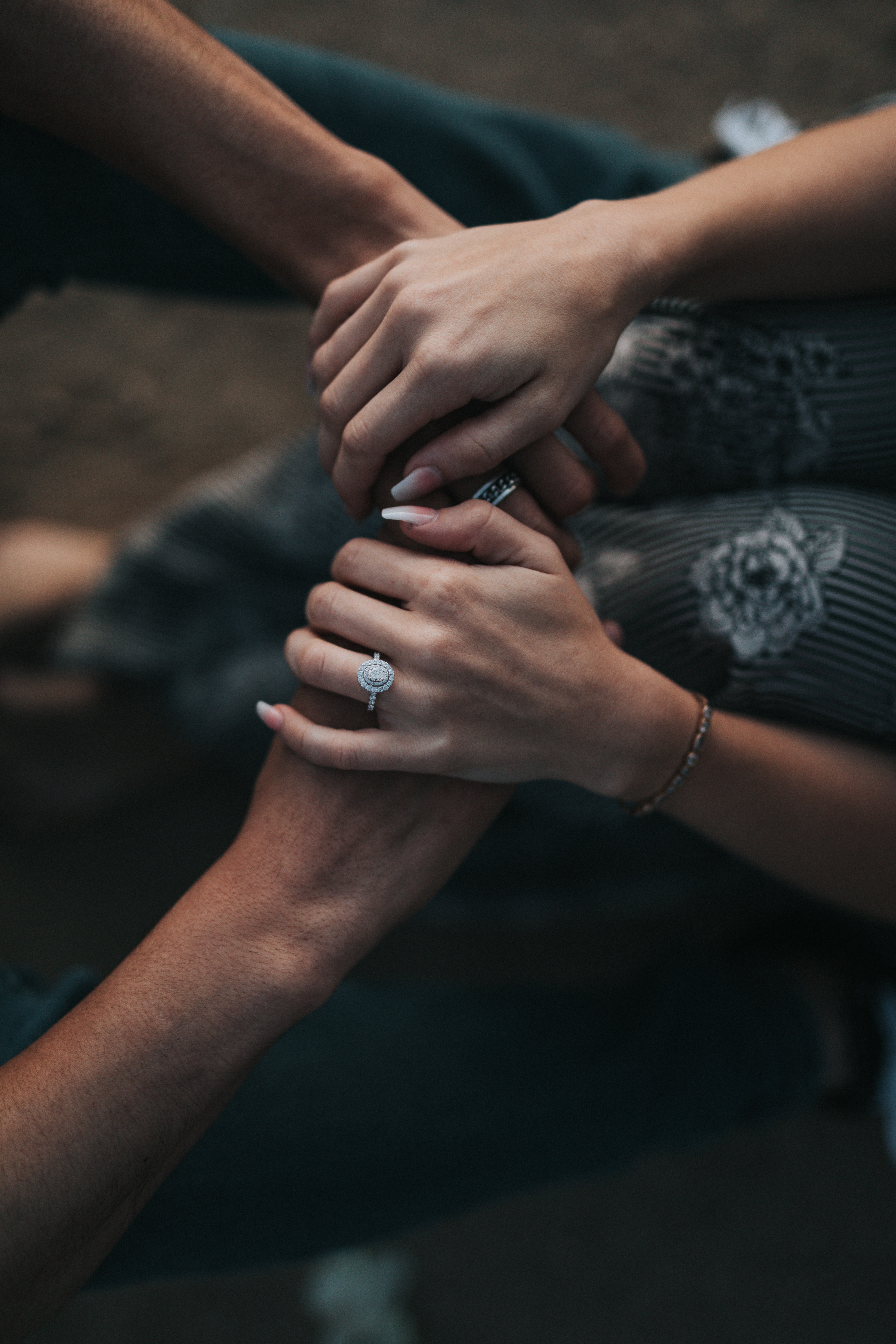 Dos personas tomadas de la mano, con los anillos a la vista.