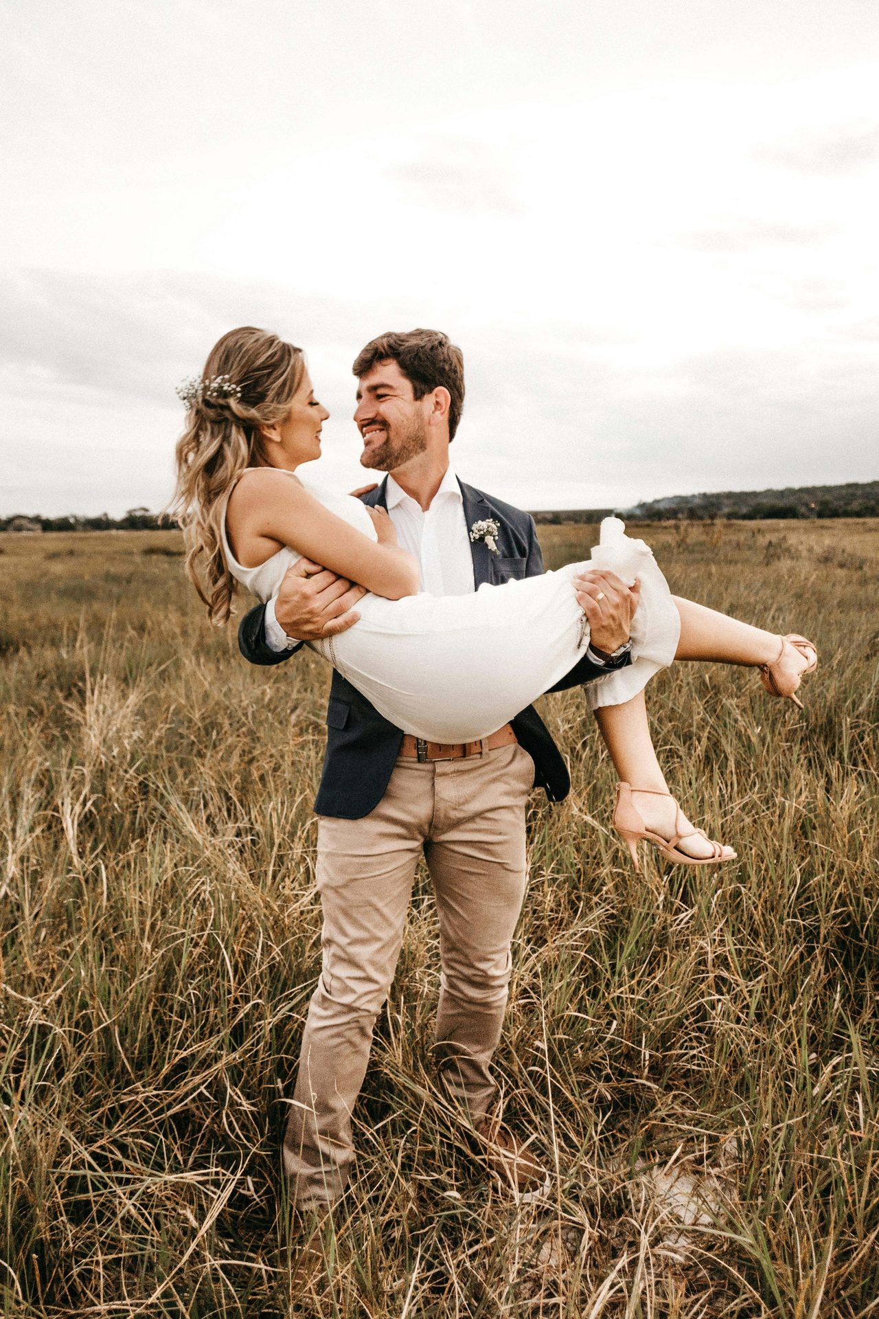 newlyweds walking in field