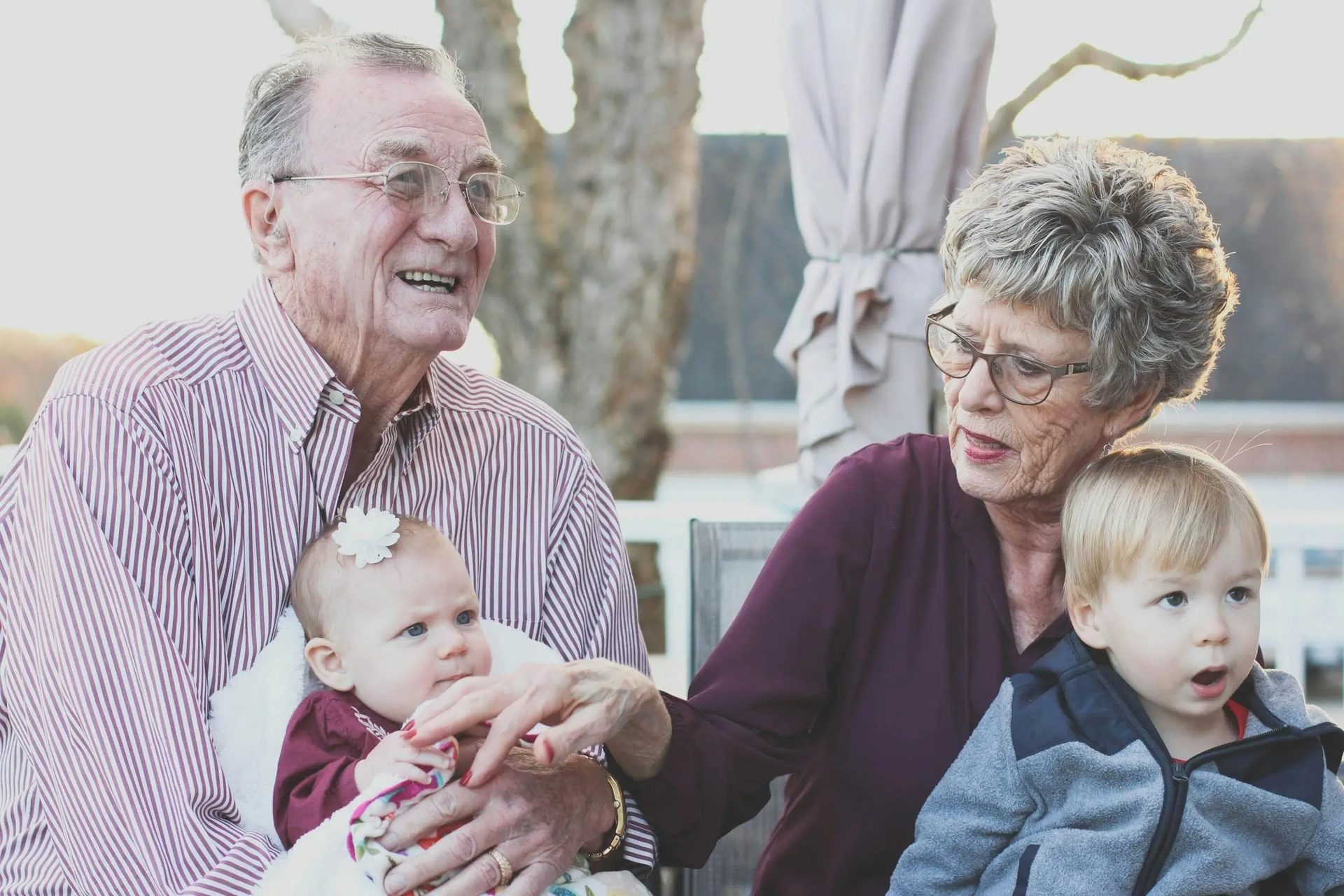 Two older adults sitting with two young children.