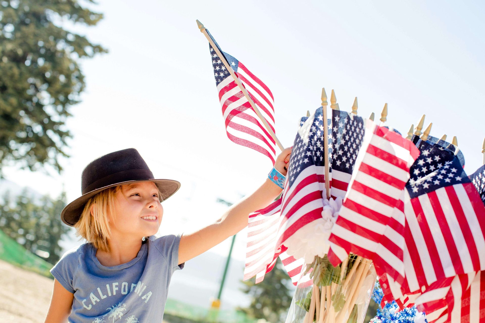A child holding several American flags.