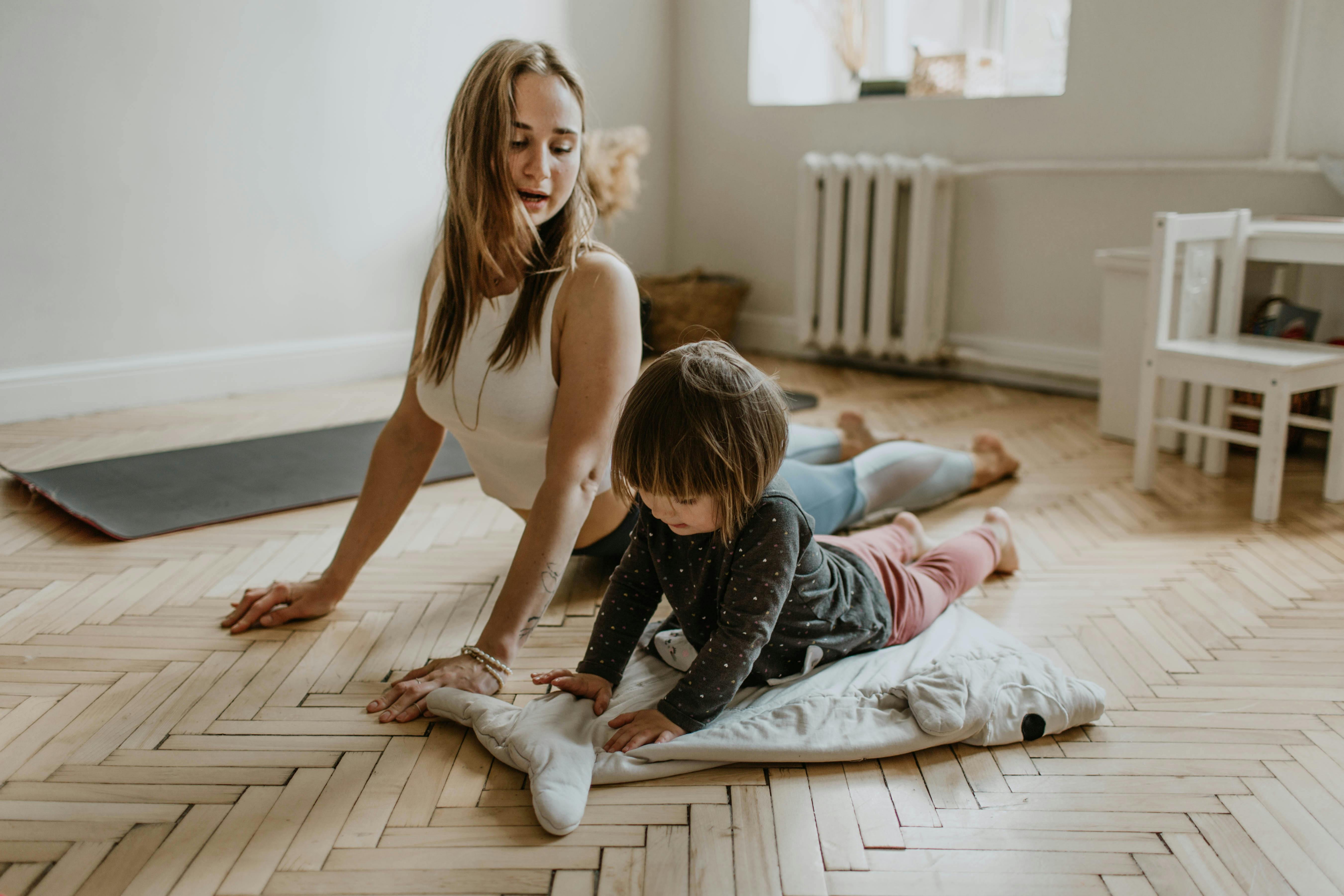 An adult and child stretching together indoors.