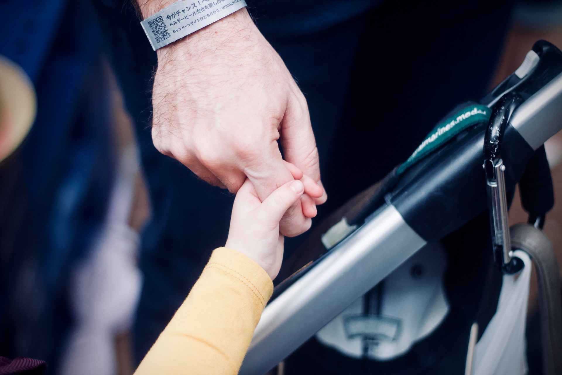 child holding hand of father