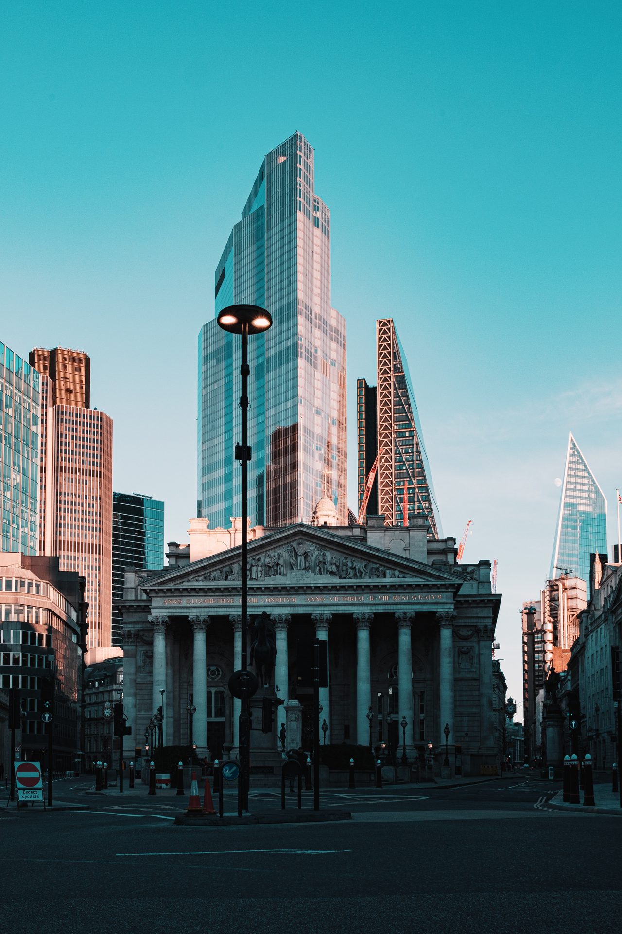 A stone building in front of taller city buildings.